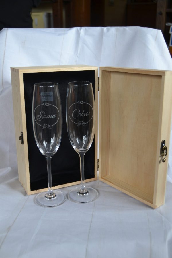 Caja de madera de boda abierta con interior forrado en terciopelo negro y copas grabadas con nombres y fecha